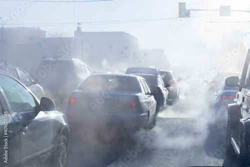 pollution from the exhaust of cars in the city in the winter. Smoke from cars on a cold winter day