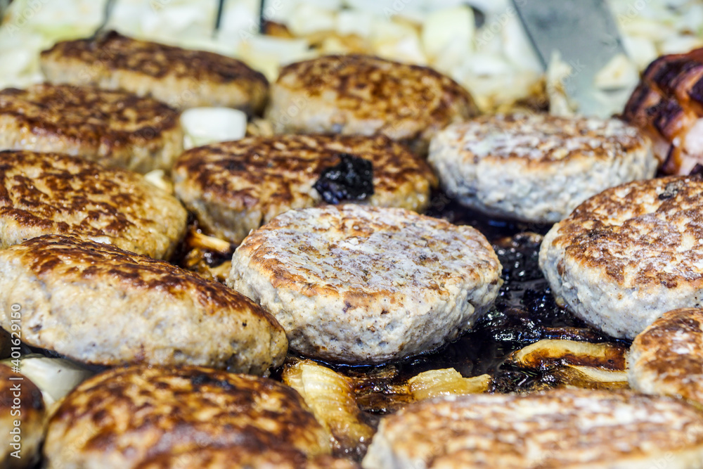 An hamburgher is cooking in a hot barbeque An hamburgher is cooking in a hot barbeque
