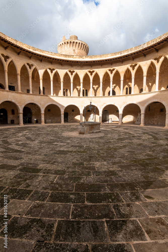 Arcades of the inner courtyard of Bellver castle with a water well in the middle in Mallorca, Spain