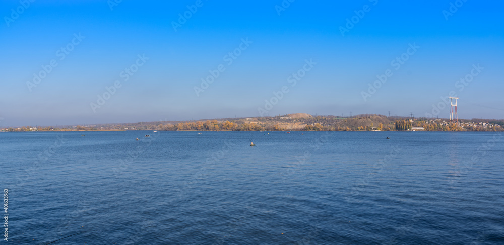 Panorama. Beautiful natural landscape on the Dnieper river with fishermen on the background of a green island and blue sky