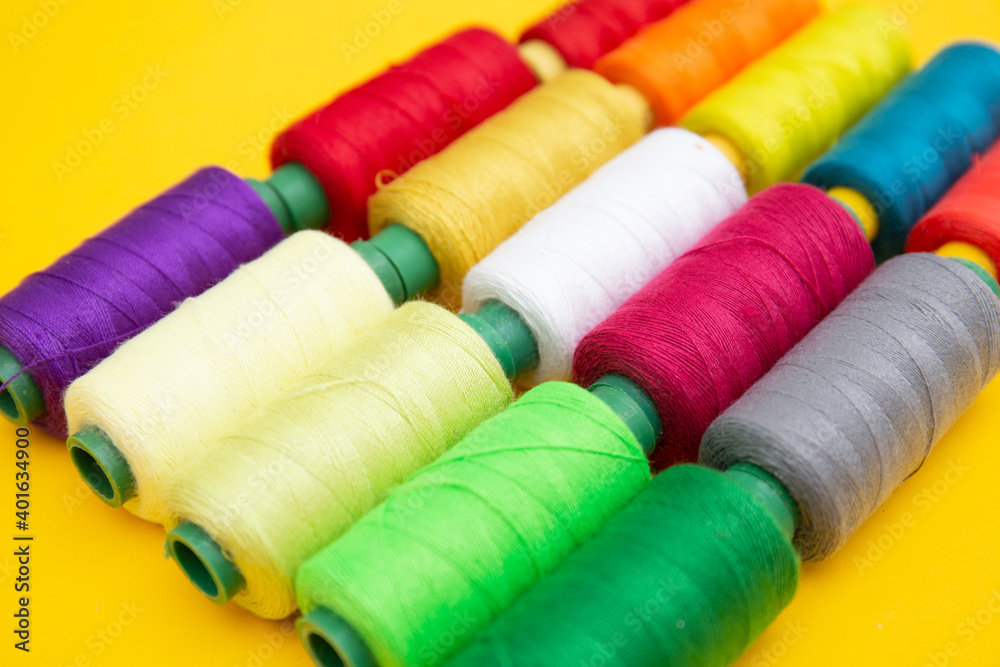 Color sewing threads on yellow background Color sewing threads on yellow background