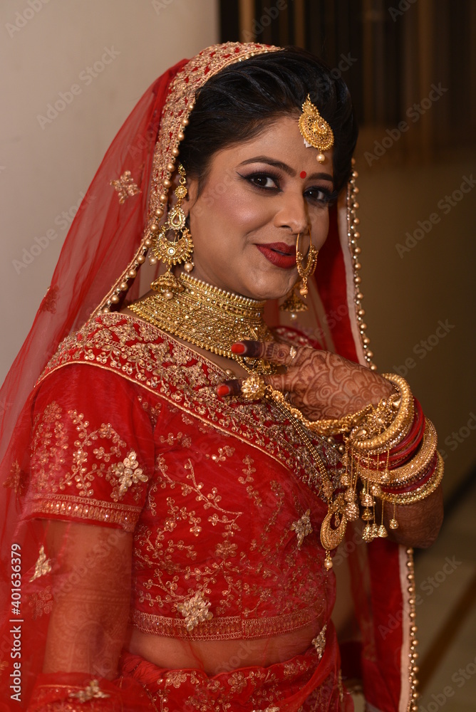Cute Indian bride posing with victory sign for photograph 