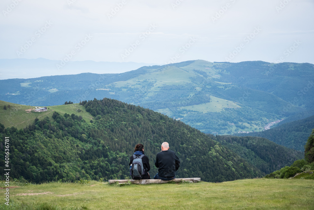 un couple de randonneurs assis à la montagne. Des gens  touristes regardant le paysage de montagne. Des gens contemplant la montagne