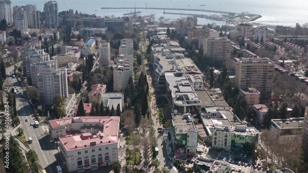 Sochi city at sunny day with architecture district downtown infrastructure surrounded by sunlight sea pier and sky. Aerial drone view amazing modern touristic town resort at seashore nature scenery. Sochi city at sunny day with architecture district downtown infrastructure surrounded by sunlight sea pier and sky. Aerial drone view amazing modern touristic town resort at seashore nature scenery.