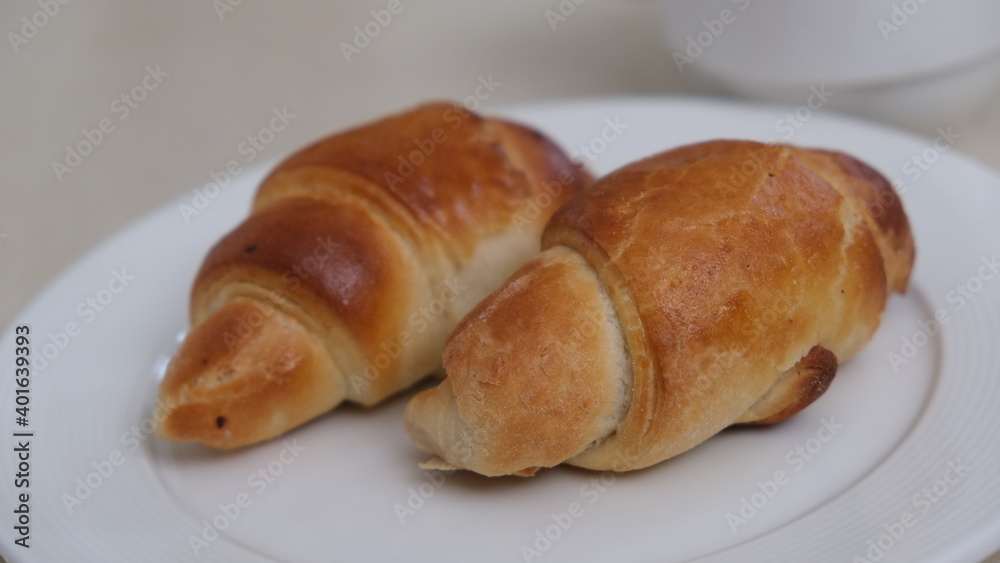 Croissants on white plate. Breakfast. Pastries.