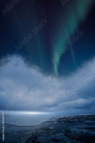 Northern lights over an ocean and clouds