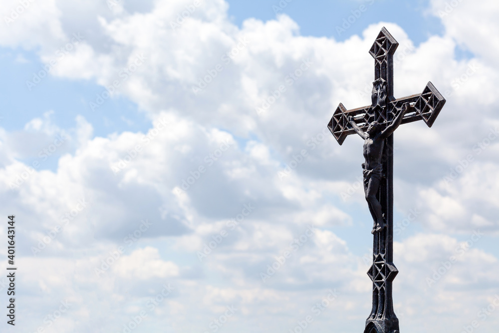 Metal christian cross on blue cloudy sky background, copy space. Catholic church symbol, Jesus Christ Faith, spirituality, chrisitanity and catholicism Religious symbols abstract, crucifix, text space Metal christian cross on blue cloudy sky background, copy space. Catholic church symbol, Jesus Christ Faith, spirituality, chrisitanity and catholicism Religious symbols abstract, crucifix, text space