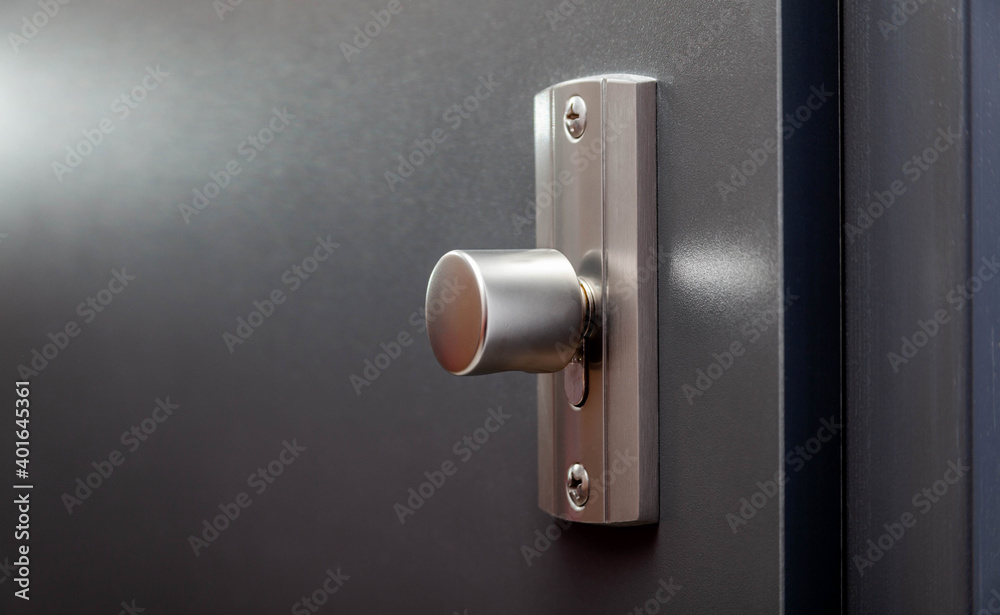 Modern apartment closed front door inside metal doorknob lock closeup, detail. House main entrance interior turn door handles knob macro, block of flats private property protection, safety concept Modern apartment closed front door inside metal doorknob lock closeup, detail. House main entrance interior turn door handles knob macro, block of flats private property protection, safety concept
