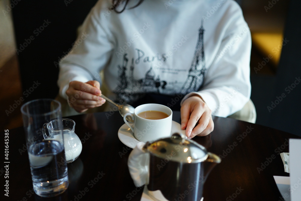 カフェでミルクティーを飲む女性