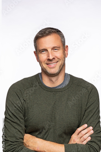 middle aged Caucasian male smiling with arms crossed portrait image