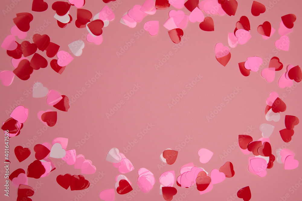 Valentine day composition with copy space. Frame made of confetti hearts red and pink on pastel background. Close up, top view, copy space