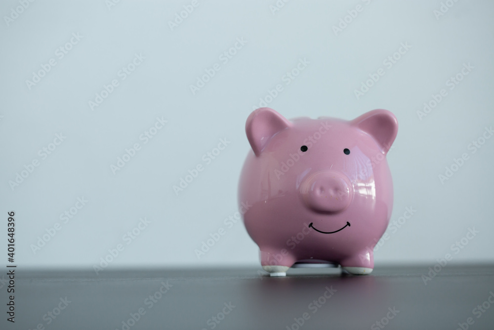 Pink piggy bank on wooden table and white background indoors-Concept of money savings through online