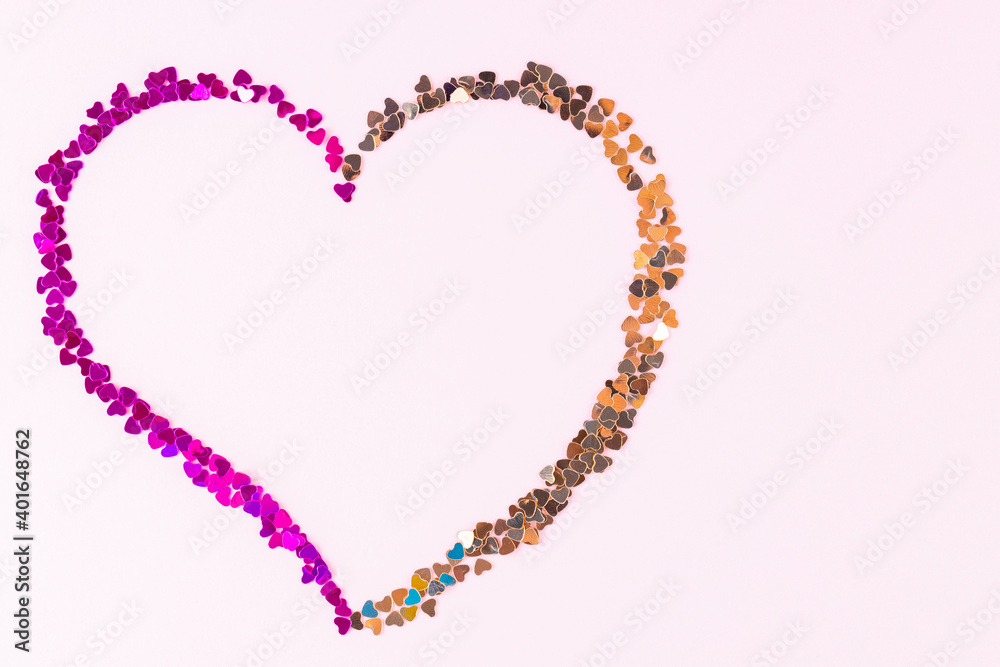 Happy Valentine's Day. Heart shape made of multicolored glitter. Heart made from shiny colorful sparkles on pink background. Love concept. Copy space. Top view