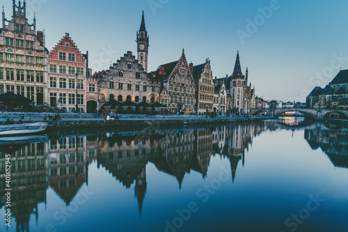 Picturesque medieval buildings overlooking the Graslei harbor on Leie river in Ghent town, Belgium, Europe at dusk.