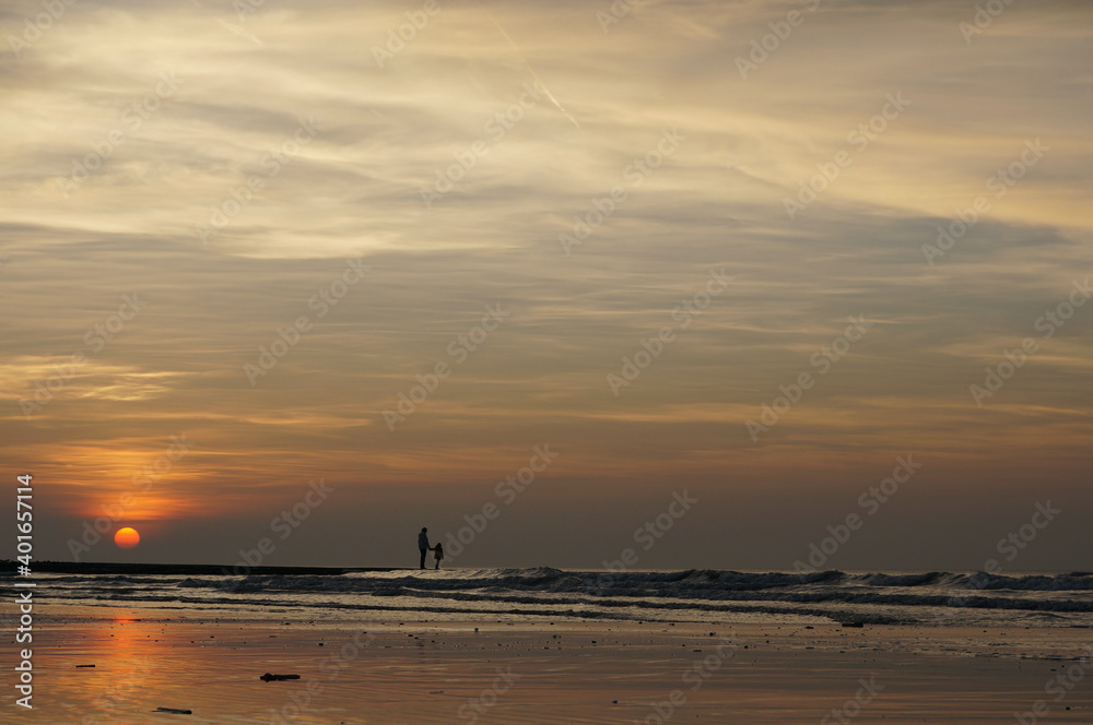 Père et fille sur une plage au coucher de soleil en Belgique Père et fille sur une plage au coucher de soleil en Belgique