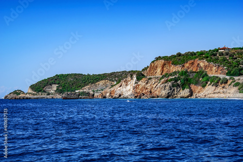 Boat trip on the background of the rocky coast of Alanya (Turkey). Seascape with views of stone coastline and blue sea water