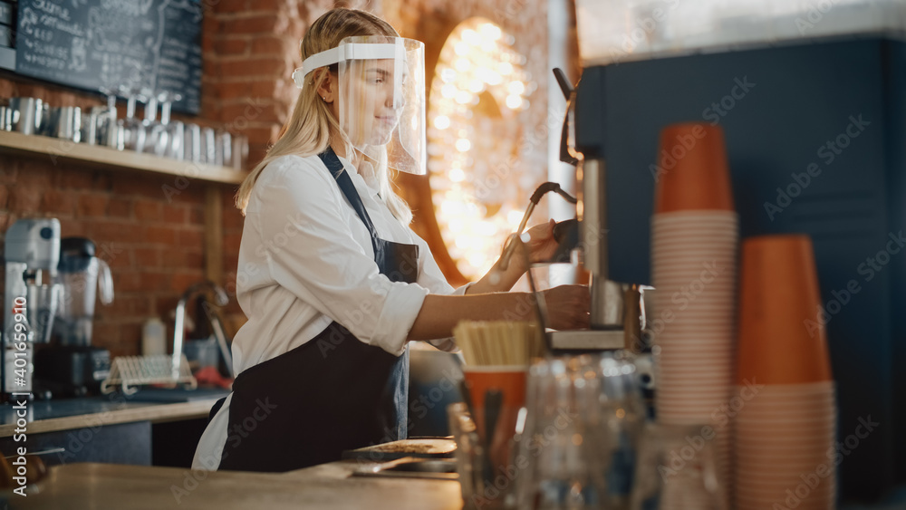 Beautiful Young Barista Wearing Face Shield is Making a Cup of Fresh Coffee in a Cafe. Bar Employee Working in Coffee Shop Restaurant. Social Restrictions Concept During Coronavirus Pandemic.