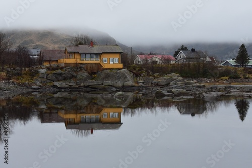 landscape of villages reflection on the lake with white fog in raining day at lofoten island norway.The rorbuer reflectionin the lake photo