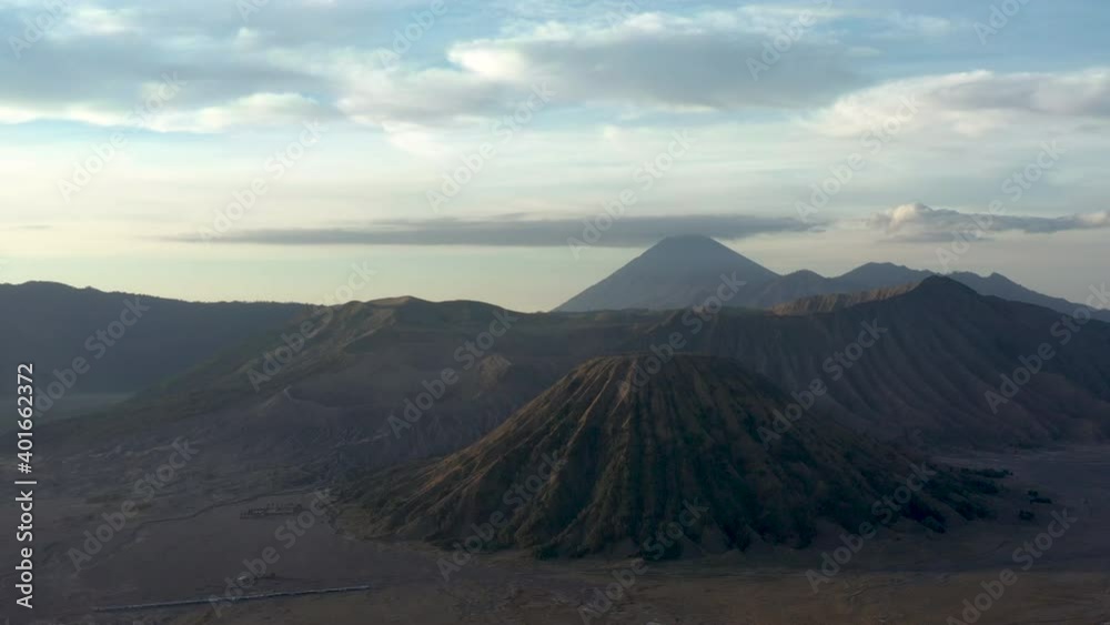 View from above, stunning aerial view of the Mt Batok and Mt Bromo with its massive crater illuminated during a sunny day. Mt Bromo is an active volcano in East Java, Indonesia. View from above, stunning aerial view of the Mt Batok and Mt Bromo with its massive crater illuminated during a sunny day. Mt Bromo is an active volcano in East Java, Indonesia.
