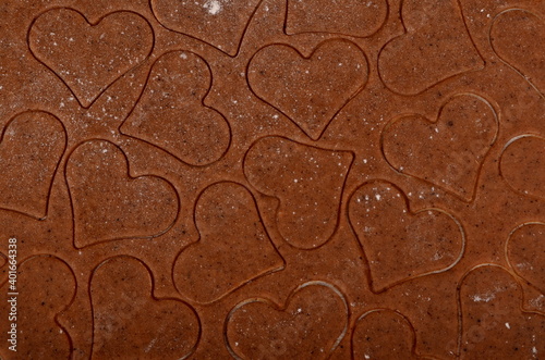 Flat rolled Raw dough for cooking Christmas cookies with ginger heart and other shapes, top view, Gingerbread dough background