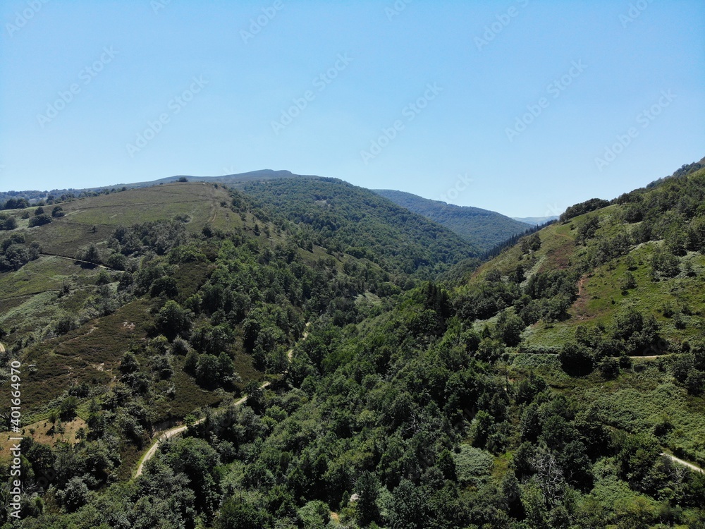 Aerial view of beautiful mountains full of trees and vegetation in the north of Spain on a sunny day