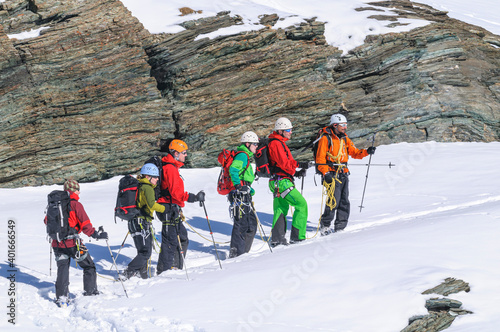 Bergführer geht mit seiner Gruppe am Seil. photo