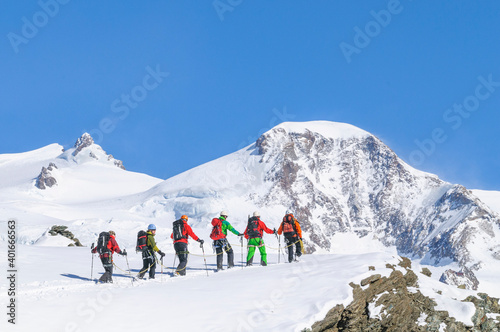Bergführer geht mit seiner Gruppe am Seil.