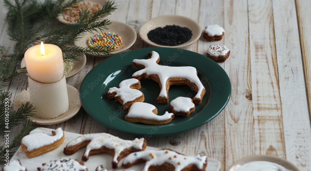 Homemade Christmas cookies in the shape of animals are laid out on a wooden background with fir branches. Christmas decor. Homemade Christmas cookies in the shape of animals are laid out on a wooden background with fir branches. Christmas decor.