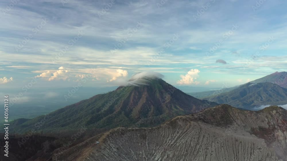 Stunning aerial view of a beautiful mountain range surrounded by clouds during sunrise. Ijen Volcano complex. The Ijen volcano complex is a group of composite volcanoes located in East Java, Indonesia