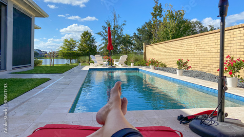 Valokuva A relaxing backyard swimming pool with red umbrellas