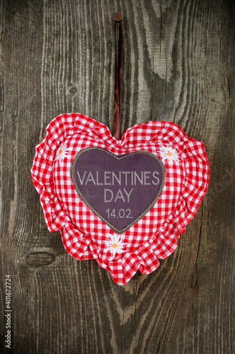 Red and white heart on a weathered wood and valentines day and the german word valentinstag