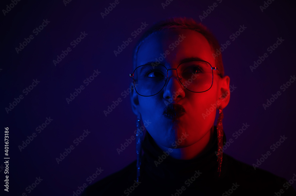 Close-up portrait of young blonde woman with short hair wearing glasses in neon light Close-up portrait of young blonde woman with short hair wearing glasses in neon light