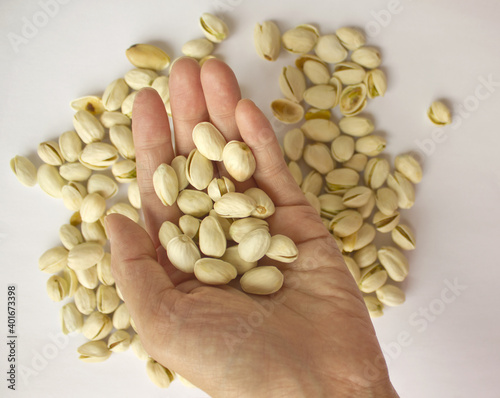 Pistachio nuts and woman s hands. Pistachios isolated on white background  top view. 