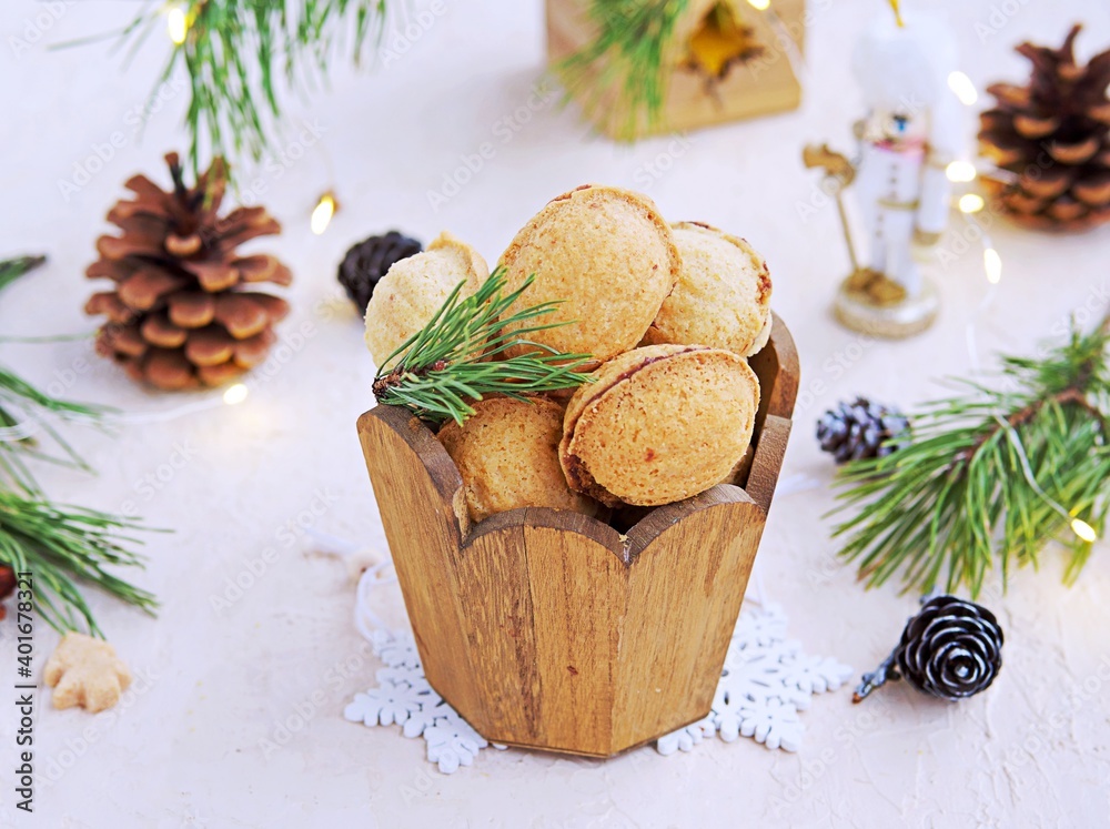 Shortbread cookies Nuts stuffed with chocolate paste or condensed milk in a wooden jar in a Christmas and New Year style on a light concrete background. Cookie recipes.