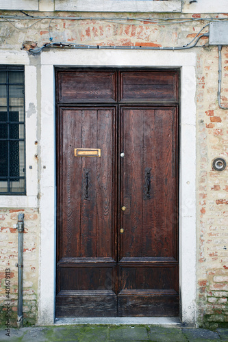 Italian Vinice retro wood style front door, the main entrance. Element of the classic Venetian facade and architecture