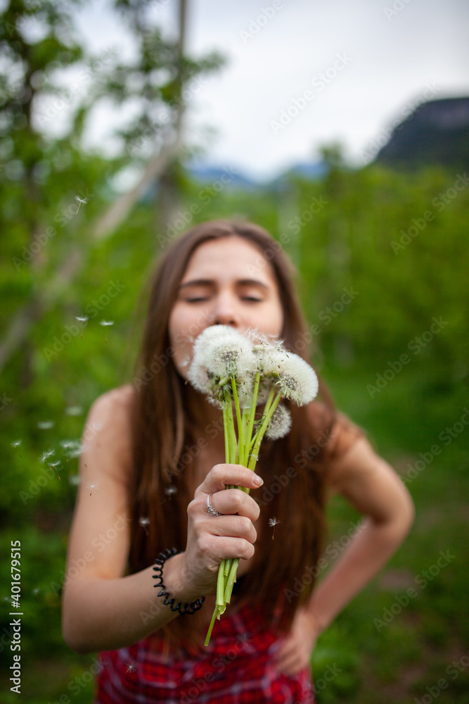Obraz premium Girl with dandelion on green field