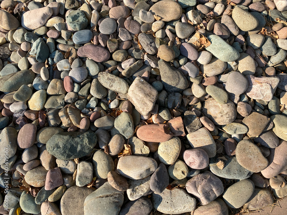 multicolored and different shaped pebble rock stones in direct sunlight with deep shadows multicolored and different shaped pebble rock stones in direct sunlight with deep shadows