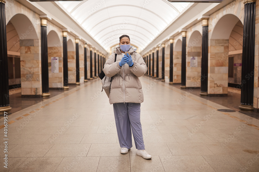 Portrait of woman in warm clothing making selfie on her mobile phone while standing in subway