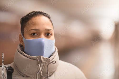 Portrait of young woman wearing protective mask looking at camera