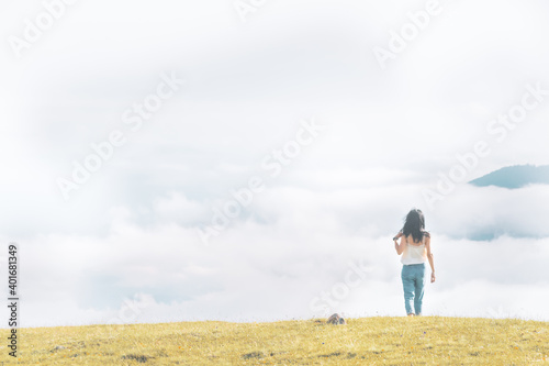 Woman relaxed walks towards the cloudscape in pristine nature. concept of freedom and life