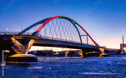Lowry Avenue Bridge colored red and green at dusk on Christmas day with Minneapolis Skyline behind 