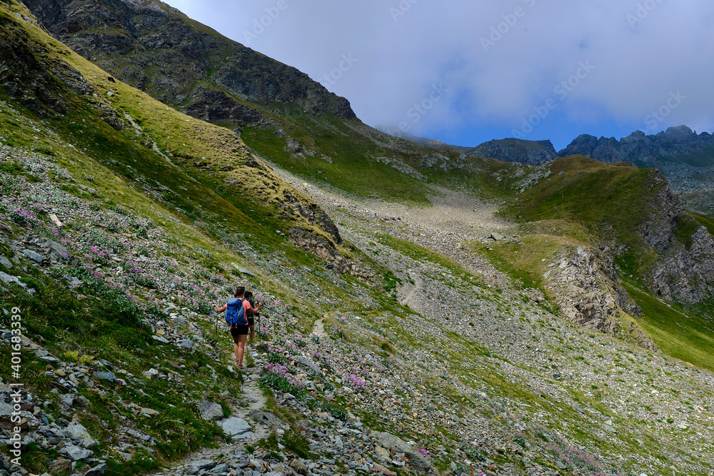 Young friends boys and girls walk in the mountains, along paths trought rocks and nature. 