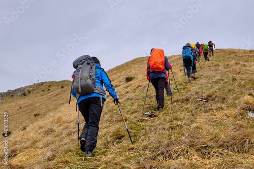 Young friends boys and girls walk in the mountains, along paths trought rocks and nature. 