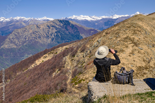 Young friends boys and girls walk in the mountains, along paths trought rocks and nature. 