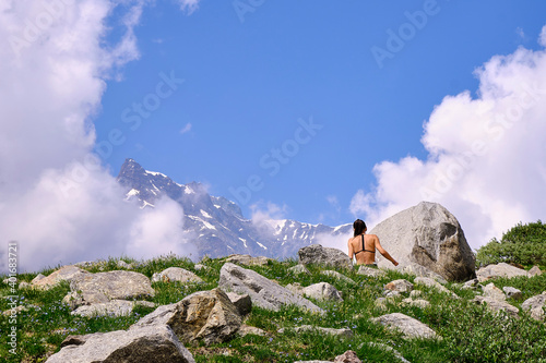 Young friends boys and girls walk in the mountains, along paths trought rocks and nature. 