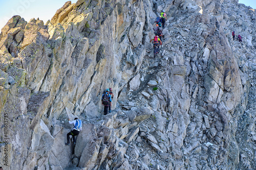 Young friends boys and girls walk in the mountains, along paths trought rocks and nature. 