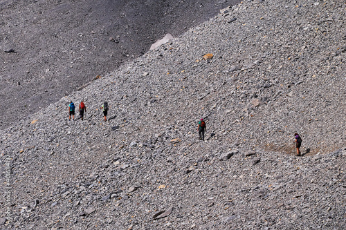 Young friends boys and girls walk in the mountains, along paths trought rocks and nature. 
