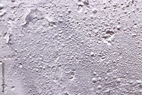Texture of a gray wall with aged paint. Empty plain silver background.
