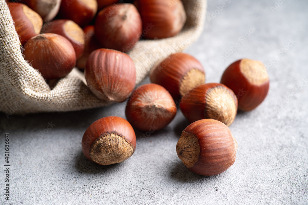Hazelnuts in shell in pouch on the rustic background. Selective focus. Hazelnuts in shell in pouch on the rustic background. Selective focus.
