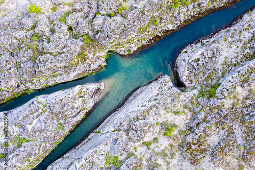 Cuadro en lienzo Fork of a narrow mountain river flowing through bare rocky landscape